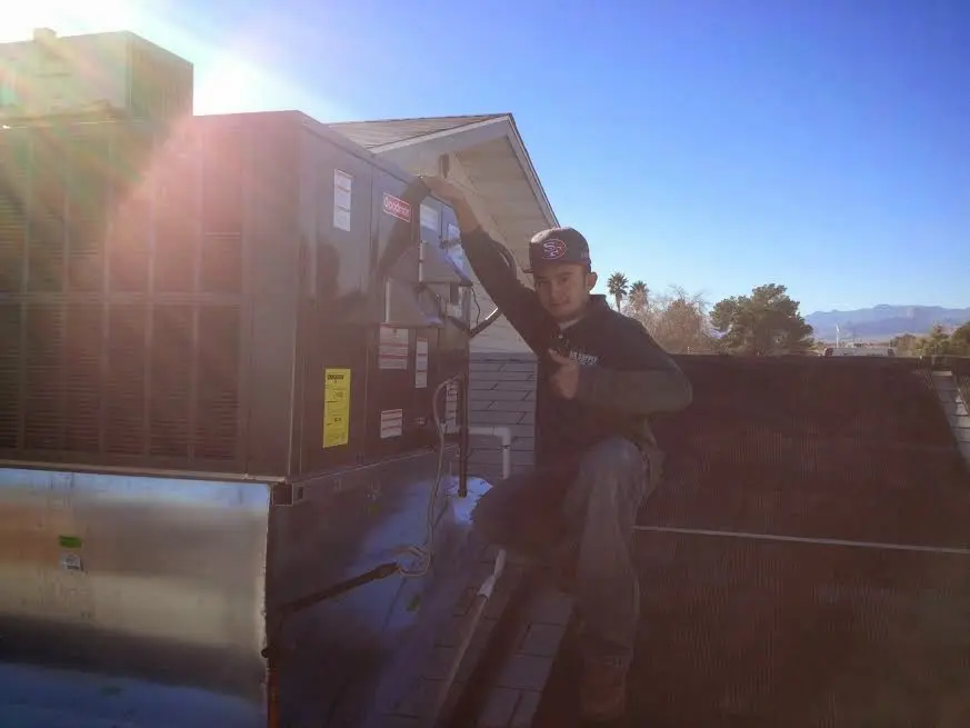 HVAC technician performing Air Duct Cleaning on a rooftop unit in Colusa